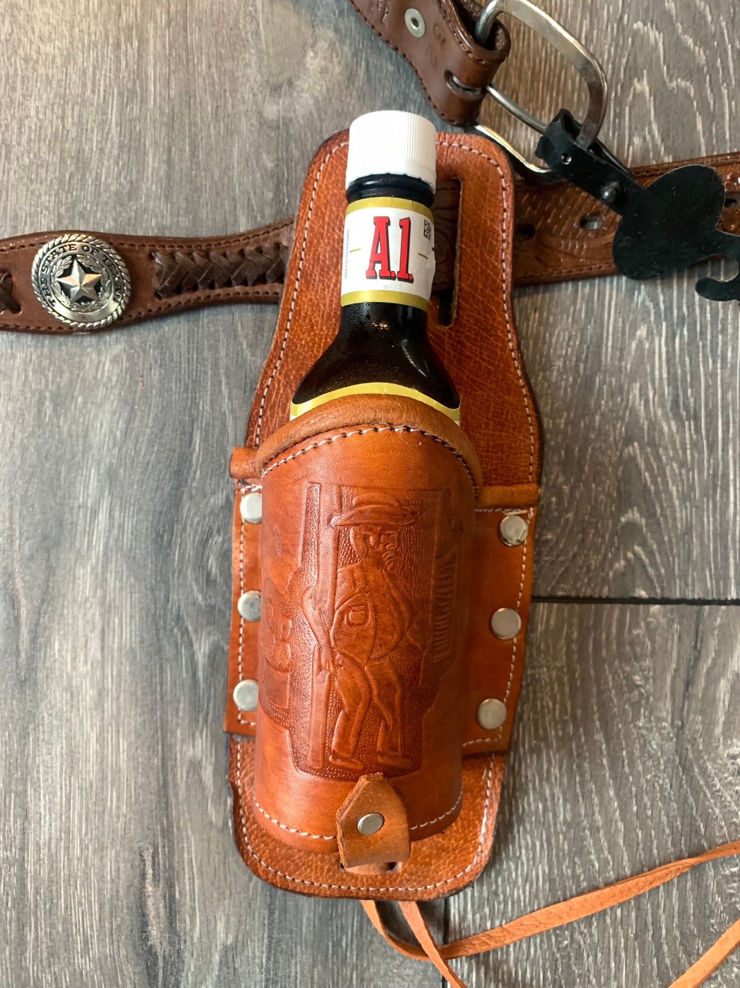 Leather Holder for Bottle Drinks

Tooled Leather Holder for Bottle Drinks. Attaches to your belt with slits...